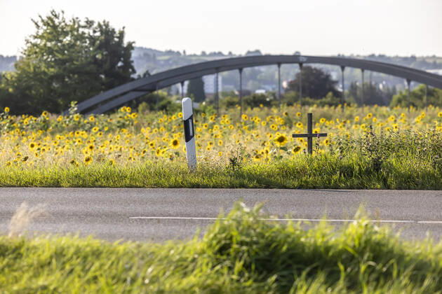 Ein Kreuz am Fahrbahnrand erinnert an ein Opfer des Straßenverkehrs. 12.08.2021: Deutschland, Baden-Württemberg, Rottenburg am Neckar.