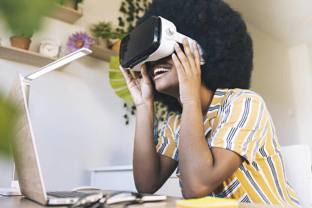Happy young woman using virtual reality simulator at home model released Symbolfoto property released JCCMF03315