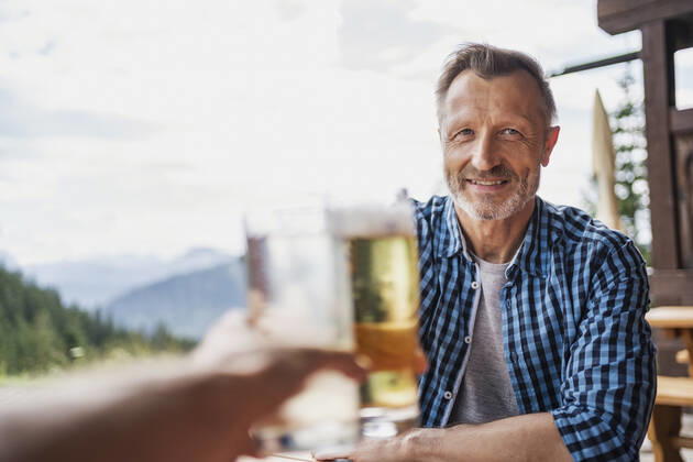 Smiling man toasting beer glass with friend at bar model released Symbolfoto DIGF16313