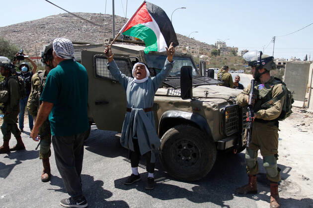August 25, 2021, Nablus, West Bank, Palestine: A protester chants slogans while holding a flag during the demonstration..Palestinians protest against the construction of a new road for Israeli settlers, and also call for the removal of the Israeli outpost Eviatar near Beita, south of Nablus in the West Bank. Nablus Palestine - ZUMAs197 20210825_zaa_s197_103 Copyright: xNasserxIshtayehx
