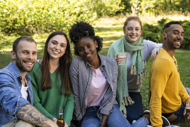 IMAGO Creative: Jahreszeit Frühling, Picknick Smiling young friends sitting together in public park Copyright: FrédéricxCirou B42300147