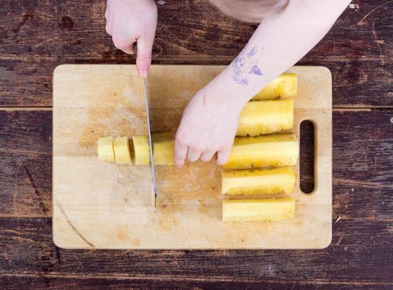  A girl is cutting a pineapple model released, Symbolfoto, 11.10.2020, Copyright: xcoramullerx Panthermedia21999693