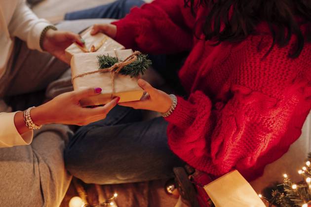 IMAGO Creative: Weihnachten, DIY, Geschenke verpacken - Nachhaltigkeit Female friends giving Christmas present at home model released Symbolfoto property released EGHF00180