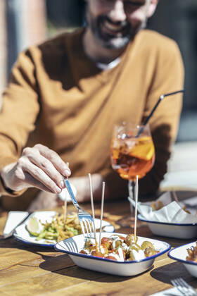 IMAGO Creative, Food, Tapas Smiling man eating tapas at restaurant model released Symbolfoto property released JSRF01607