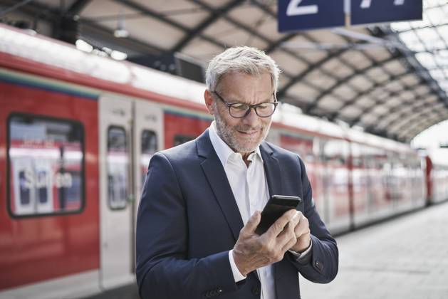 IMAGO Creative: Neue Aussichten Male professional using mobile phone while standing on railroad platform model released Symbolfoto RORF02834
