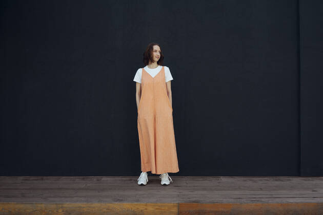 Young woman with hands in pockets standing in front of black wall model released Symbolfoto VPIF04559
