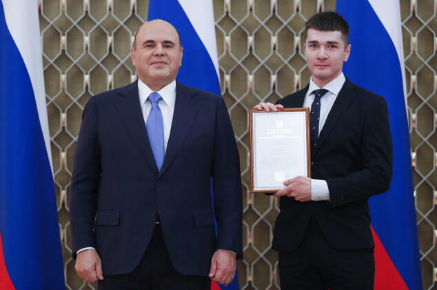 MOSCOW, RUSSIA - OCTOBER 5, 2021: Russia s Prime Minister Mikhail Mishustin (L) poses with Artyom Malykh, lab assistant at the Psychological Institute of the Russian Academy of Education, during a ceremony to award commendations and state prizes in the field of education and mark Teachers Day. Dmitry Astakhov POOL TASS  TS113220