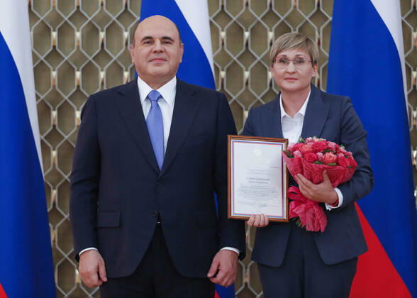 MOSCOW, RUSSIA - OCTOBER 5, 2021: Russia s Prime Minister Mikhail Mishustin (L) poses with Tatyana Saifutdinova, Director for Educational Programmes at the Orlyonok Russian Children s Centre, during a ceremony to award commendations and state prizes in the field of education and mark Teachers Day. Dmitry Astakhov POOL TASS  TS113222