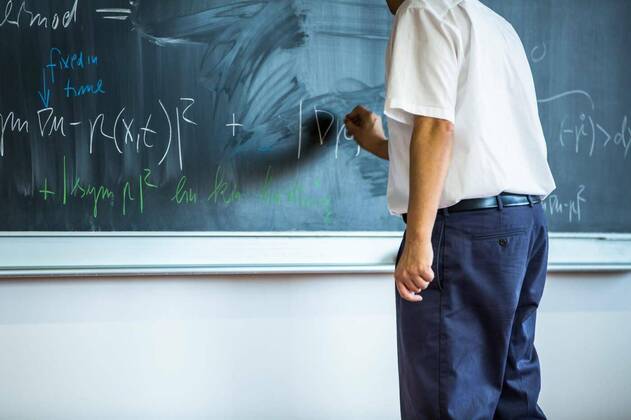 teacher teaching mathematics while pointing at blackboard in classroom model released, Symbolfoto, 13.10.2020, Copyright: xLightpoetx Panthermedia27207519