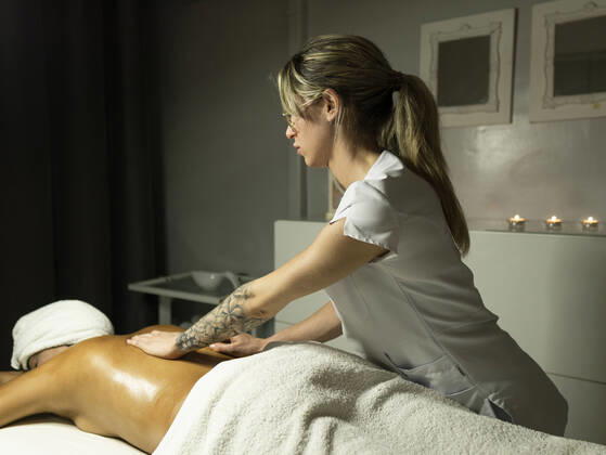 Unrecognizable female masseur massaging back of client in towel on couch in light spa center, Model released, Property released AlbertMorcillo_Hairdressing_24.jpg Copyright: xAlbertxMorcillox MR