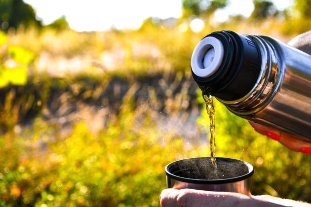 IMAGO Creative: Jahreszeit Frühling, Picknick Traveler pouring hot tea from thermos to cup at autumn fallen forest outdoor. Traveler pouring hot tea from thermos to cup at autumn fallen forest outdoor. Summer autumn picnic. Copy space Copyright: xx 38543816