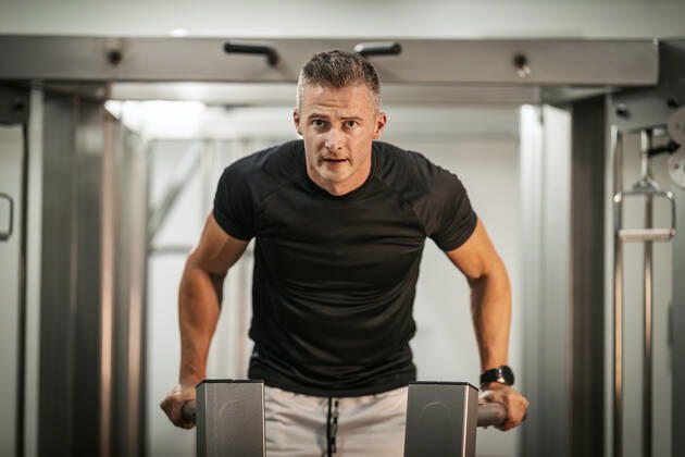 Fitness For Healthy Lifestyle Muscular young man doing hard exercises on machine during a strength training workout at the gym. Copyright: xMilanxMarkovicx 38998918