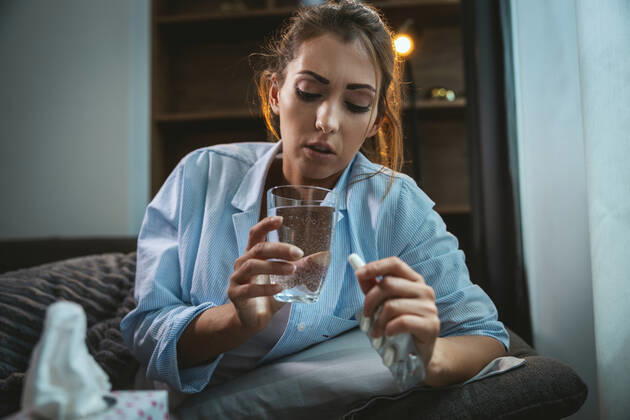 Oh No, Could It Be Flu? Young woman is lying sick at home couch and taking pills. Copyright: xMilanxMarkovicx 38999470
