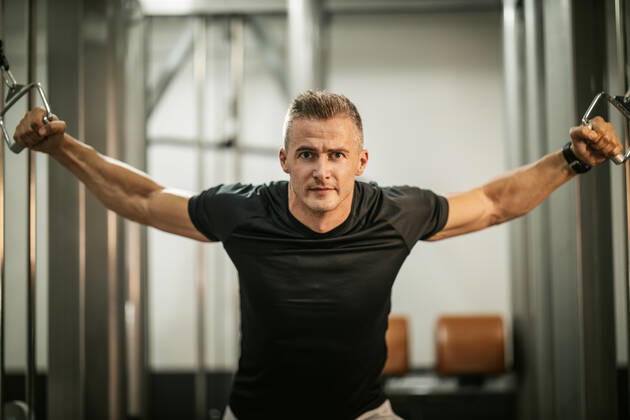 Fitness For Healthy Lifestyle Muscular young man doing hard exercises for chest on cable machine during a strength training workout at the gym. Copyright: xMilanxMarkovicx 39002392