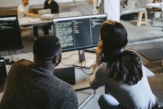 Male and female programmers coding over computer in creative office Germany, Berlin, model released, property released Copyright: xMaskotx , MA90141