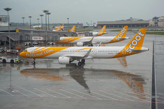 15.11.2021, Singapur, Republik Singapur, Asien - Ein Airbus A321neo Passagierflugzeug der Scoot Airlines mit der Registrierung 9V-NCB beim Pushback auf dem internationalen Flughafen Changi und parkenden Flugzeugen im Hintergrund. Scoot ist eine Billigfluggesellschaft aus Singapur und eine Tochtergesellschaft der Singapore Airlines.