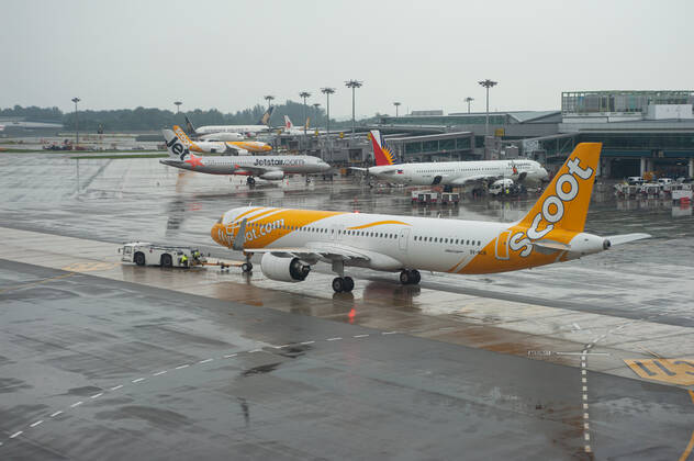 15.11.2021, Singapur, Republik Singapur, Asien - Ein Airbus A321neo Passagierflugzeug der Scoot Airlines mit der Registrierung 9V-NCB beim Pushback auf dem internationalen Flughafen Changi und parkenden Flugzeugen im Hintergrund. Scoot ist eine Billigfluggesellschaft aus Singapur und eine Tochtergesellschaft der Singapore Airlines.
