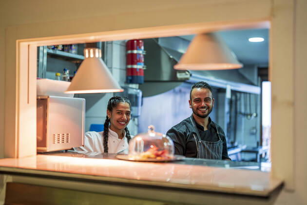 IMAGO Creative: Internationaler Frauentag, Gender Pay Gap, Frauen verdienen 18 Prozent weniger IMAGO Creative: Landleben - Essen Smiling chef and trainee in commercial kitchen at restaurant model released property released, DLTSF02398