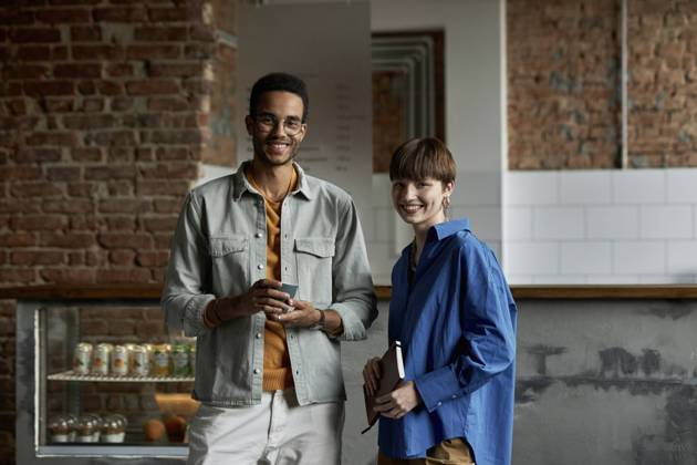 IMAGO Creative: Gesellschaft, Integration Smiling couple standing in modern cafe model released property released, DSHF00088