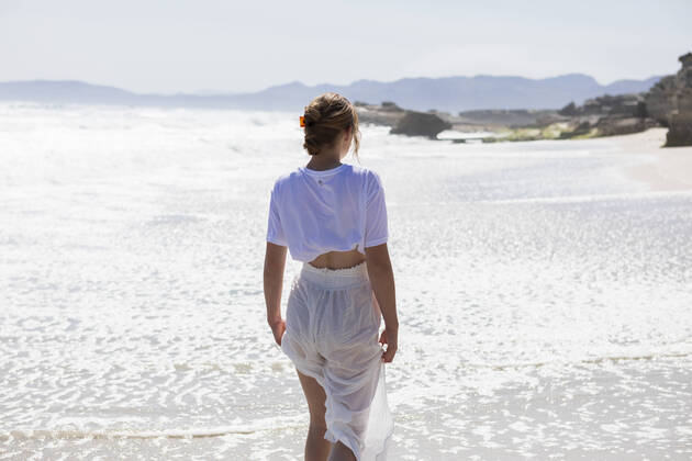 IMAGO Creative: Kulturelle Folgen der Pandemie: Gesundheitsbewußtsein und Alleinsein Teenage girl alone on a sandy beach in South Africa by the water s edge looking at the coastal view South Africa,Teenage girl alone on a sandy beach in South Africa by the water s edge looking at the coastal view Teenage girl alone on a sandy beach in South Africa by the water s edge looking at the coastal view