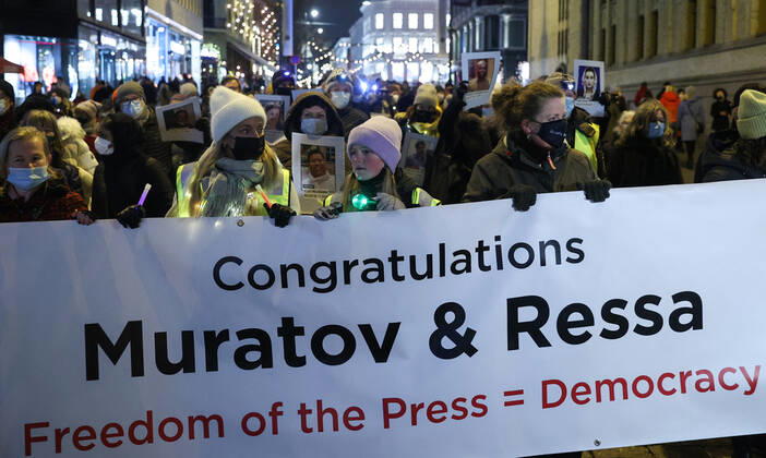 OSLO, NORWAY â€“ DECEMBER 10, 2021: People take part in a torchlight parade in honour of the 2021 Nobel Peace Prize winners from Oslo Central Station to the Grand Hotel where the laureates greet the procession participants from the balcony. The Norwegian Nobel Committee has decided to award the Nobel Peace Prize for 2021 to Filipino-American journalist, co-founder and CEO of Rappler Maria Ressa and Russian journalist, Novaya Gazeta editor-in-chief Dmitry Muratov in recognition of their efforts to safeguard freedom of expression, which is a precondition for democracy and lasting peace . Sergei Bobylev TASS  TS11B65A