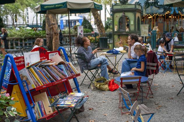 People enjoying in Bryant Park a City park in Mid-town Manhattan, New York City , NY ,USA Visitors browse the selection of books on carts at the Reading Room, an open air library in New York City s Bryant Park New York New York USA Copyright: xx SRE-BS6464