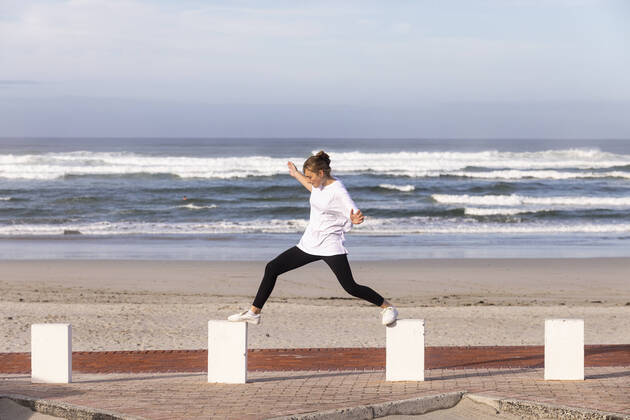 IMAGO Creative: Kulturelle Folgen der Pandemie: Gesundheitsbewußtsein und Alleinsein A teenage girl balancing on posts on a sandy beach. Grotto Beach,South Africa,A teenage girl balancing on posts on a sandy beach. A teenage girl balancing on posts on a sandy beach.