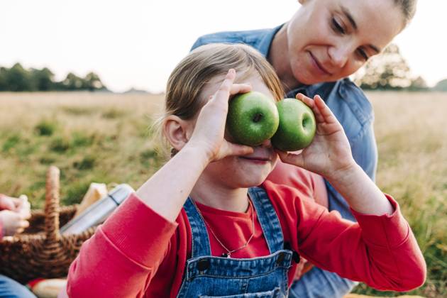 Mother looking at daughter playing with fruits in park model released, ASGF01692