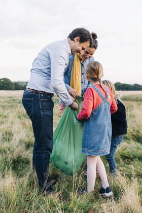 IMAGO Creative: Jahreszeit Frühling, Picknick Family collecting garbage in plastic bag after picnic at park model released, ASGF01699