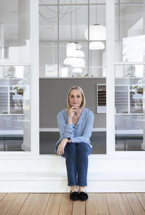 Smiling businesswoman with hand on chin at office doorway model released property released, FKF04604