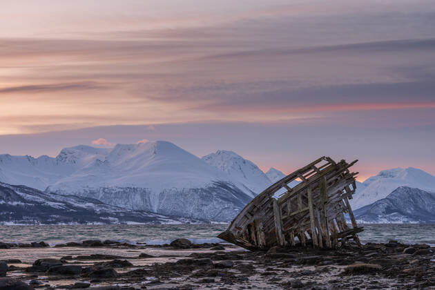 Shipwreck lying on shore of secluded Fjord at winter dawn, RUEF03445