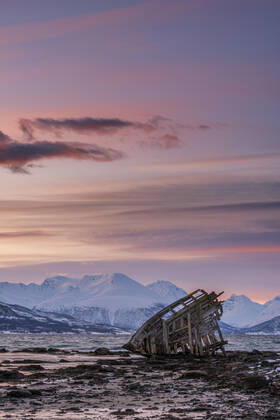 Shipwreck lying on shore of secluded Fjord at winter dawn, RUEF03446