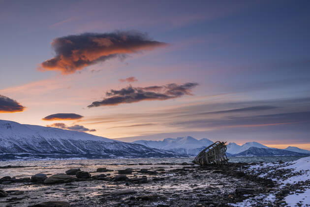 Shipwreck lying on shore of secluded Fjord at winter dawn, RUEF03447