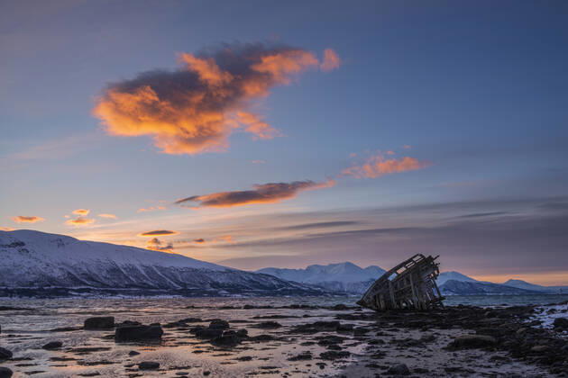 Shipwreck lying on shore of secluded Fjord at winter dawn, RUEF03448