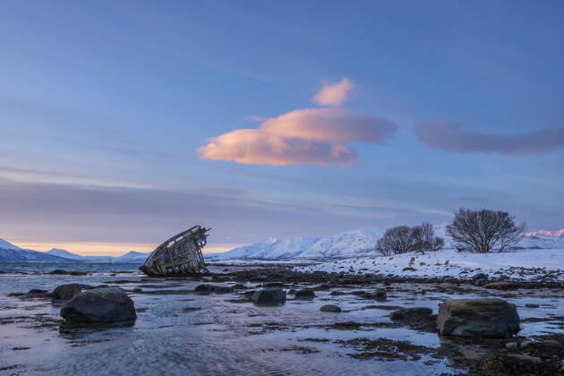 Shipwreck lying on shore of secluded Fjord at winter dawn, RUEF03450
