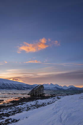 Shipwreck lying on shore of secluded Fjord at winter dawn, RUEF03451