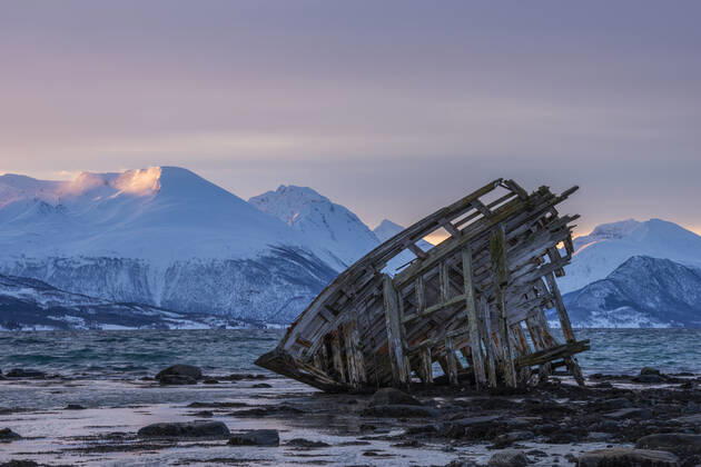 Shipwreck lying on shore of secluded Fjord at winter dawn, RUEF03452