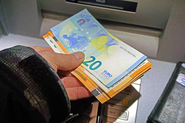 Bargeldversorgung aus einem Automat Eine Person holt an einem Geldautomaten Bargeld in 50 und 20 Euro Geldscheinen ab