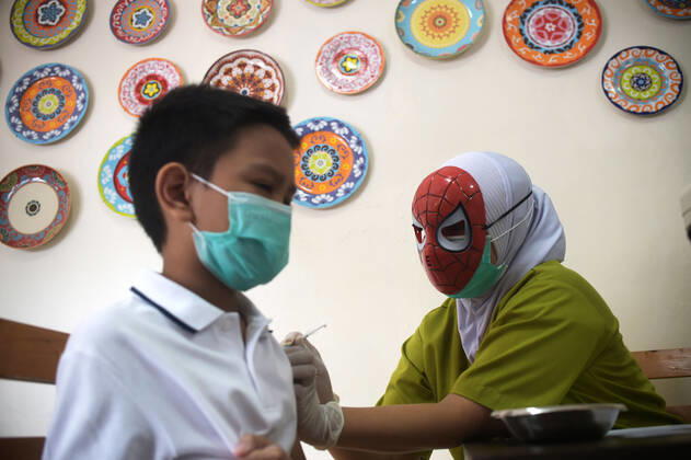 Bilder des Jahres 2021, News 12 Dezember News Bilder des Tages (211229) -- JAKARTA, Dec. 29, 2021 -- A medical worker wearing a superhero character mask administers a dose of COVID-19 vaccine to a child during vaccination for children aged 6 to 11 at RSIA Tambak Hospital in Jakarta, Indonesia, Dec. 29, 2021. ) INDONESIA-JAKARTA-COVID-19-CHILDREN-VACCINATION Zulkarnain 
