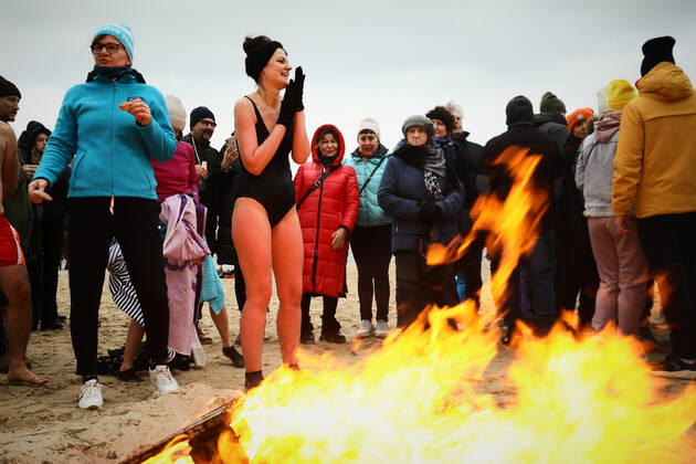 New Year s Cold Water Swim In Baltic Sea A woman warms up by a fire after a cold water swi in the Baltic Sea in Gdansk, Poland on 01 January, 2022. About a hundred people took part in the traditional New Year s swim in the Baltic Sea braving the ice cold waters. Gdansk Poland  Copyright: xSTRx originalFilename: arriens-newyears220101_np982.jpg