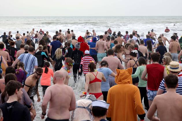 Over 350 New Year revellers, many in fancy dress, take part in the New Year Big Dip at East Wittering Beach in Chichester, West Sussex. More than double the previous record number of people took part, making the most of the warmest New YearÕs Day on record in the UK. JANUARY 1st 2022  MTXx2201