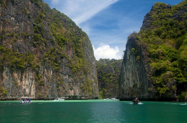 Ko Phi Phi consists of two islands, Phi Phi Leh and Phi Phi Don, located southeast of Phuket. Both are part of Hat Noppharat Thara Ko Phi Phi National Marine Park.<br ><br > Set in the centre of the Sea of Phuket, Ko Phi Phi is almost equidistant from Phuket and Krabi and can be reached by boat in around two hours.<br ><br > Phi Phi Don is the larger of the two islands, with scenic hills, steep cliffs, silken beaches, azure waters and remarkable bird- and sea-life. The island narrows at the middle where long, white-sand beaches are only a few hundred metres apart. Boats from Krabi and Phuket dock at Ao Ton Sai on the southern side of the island. Hat Yao or Long Beach faces south and is famous for the good snorkelling to be had on its co CPAxMediaxCo.xLtd. 1060_14_CPA0011099
