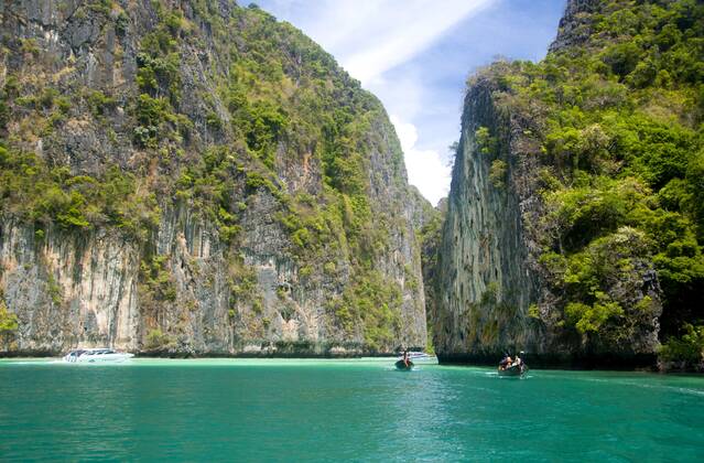 Ko Phi Phi consists of two islands, Phi Phi Leh and Phi Phi Don, located southeast of Phuket. Both are part of Hat Noppharat Thara Ko Phi Phi National Marine Park.<br ><br > Set in the centre of the Sea of Phuket, Ko Phi Phi is almost equidistant from Phuket and Krabi and can be reached by boat in around two hours.<br ><br > Phi Phi Don is the larger of the two islands, with scenic hills, steep cliffs, silken beaches, azure waters and remarkable bird- and sea-life. The island narrows at the middle where long, white-sand beaches are only a few hundred metres apart. Boats from Krabi and Phuket dock at Ao Ton Sai on the southern side of the island. Hat Yao or Long Beach faces south and is famous for the good snorkelling to be had on its co CPAxMediaxCo.xLtd. 1060_14_CPA0011464