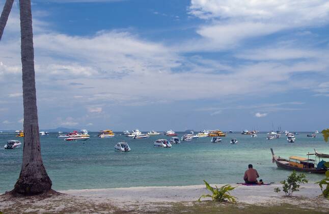 Ko Phi Phi consists of two islands, Phi Phi Leh and Phi Phi Don, located southeast of Phuket. Both are part of Hat Noppharat Thara Ko Phi Phi National Marine Park.<br ><br > Set in the centre of the Sea of Phuket, Ko Phi Phi is almost equidistant from Phuket and Krabi and can be reached by boat in around two hours.<br ><br > Phi Phi Don is the larger of the two islands, with scenic hills, steep cliffs, silken beaches, azure waters and remarkable bird- and sea-life. The island narrows at the middle where long, white-sand beaches are only a few hundred metres apart. Boats from Krabi and Phuket dock at Ao Ton Sai on the southern side of the island. Hat Yao or Long Beach faces south and is famous for the good snorkelling to be had on its co CPAxMediaxCo.xLtd. 1060_14_CPA0014897