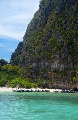 Ko Phi Phi consists of two islands, Phi Phi Leh and Phi Phi Don, located southeast of Phuket. Both are part of Hat Noppharat Thara Ko Phi Phi National Marine Park.<br ><br > Set in the centre of the Sea of Phuket, Ko Phi Phi is almost equidistant from Phuket and Krabi and can be reached by boat in around two hours.<br ><br > Phi Phi Don is the larger of the two islands, with scenic hills, steep cliffs, silken beaches, azure waters and remarkable bird- and sea-life. The island narrows at the middle where long, white-sand beaches are only a few hundred metres apart. Boats from Krabi and Phuket dock at Ao Ton Sai on the southern side of the island. Hat Yao or Long Beach faces south and is famous for the good snorkelling to be had on its co CPAxMediaxCo.xLtd. 1060_14_CPA0014907