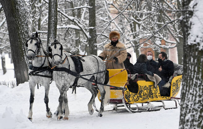 MOSCOW REGION, RUSSIA â€“ JANUARY 6, 2022: The French president s diplomatic advisor Emmanuel Bonne and the German Chancellor s foreign and security policy adviser Jens Plotner (L-R back) enjoy a ride on a horse drawn sleigh in the Arkhangelskoye museum estate before Normandy format talks with Deputy Chief of Staff of Russiaâ€™s Presidential Executive Office Dmitry Kozak (not pictured). The talks will discuss Ukraine crisis de-escalation and strengthening strategic stability in Europe. Grigory Sysoyev POOL TASS  TS11E28A