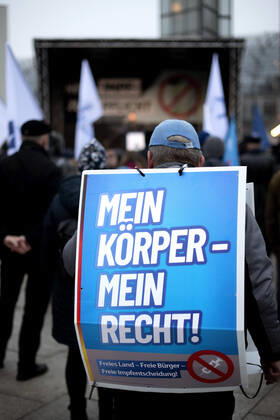 Protest AfD - Gegen Impfplicht DEU, Deutschland, Germany, Berlin, 11.12.2021 Demonstrant mit Plakat Mein Koerper Mein Recht Freies Land Freie Impfentscheidung vor Transparent Die Jugend Steht Auf Telegram Impfstreik auf einer Kundgebung und Demonstration der Jungen Alternative JA, die Jugendorganisation‹ der rechtsextremen Partei Alternative fuer Deutschland AfD gegen eine Impfpflicht und die Coronapolitik der Bundesregierung unter dem Motto Impfstreik Deutschland im Regierungsviertel in Berlin. Der Protest ist gegen das Impfen gegen Corona Covid-19 und eine moegliche Impfpflicht wird unterstuetzt von sog. Querdenker und Rechtsradikalen. Junge Alternative fuer Deutschland. en: Protester with poster Mein Koerper Mein Recht Free Land Free v