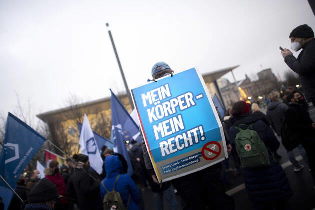 Protest AfD - Gegen Impfplicht DEU, Deutschland, Germany, Berlin, 11.12.2021 Demonstrant mit Plakat Mein Koerper Mein Recht Freies Land Freie Impfentscheidung vor Transparent Die Jugend Steht Auf Telegram Impfstreik auf einer Kundgebung und Demonstration der Jungen Alternative JA, die Jugendorganisation‹ der rechtsextremen Partei Alternative fuer Deutschland AfD gegen eine Impfpflicht und die Coronapolitik der Bundesregierung unter dem Motto Impfstreik Deutschland im Regierungsviertel in Berlin. Der Protest ist gegen das Impfen gegen Corona Covid-19 und eine moegliche Impfpflicht wird unterstuetzt von sog. Querdenker und Rechtsradikalen. Junge Alternative fuer Deutschland. en: Protester with poster Mein Koerper Mein Recht Free Land Free v
