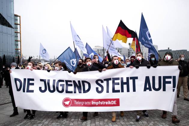 Protest AfD - Gegen Impfplicht DEU, Deutschland, Germany, Berlin, 11.12.2021 Demonstrant mit Transparent Die Jugend Steht Auf Telegram Impfstreik auf einer Kundgebung und Demonstration der Jungen Alternative JA, die Jugendorganisation‹ der rechtsextremen Partei Alternative fuer Deutschland AfD gegen eine Impfpflicht und die Coronapolitik der Bundesregierung unter dem Motto Impfstreik Deutschland im Regierungsviertel in Berlin. Der Protest ist gegen das Impfen gegen Corona Covid-19 und eine moegliche Impfpflicht wird unterstuetzt von sog. Querdenker und Rechtsradikalen. Junge Alternative fuer Deutschland. en: Protester with banner The youth stands up on Telegram vaccination strike at a rally and demonstration by the Junge Alternative JA, t