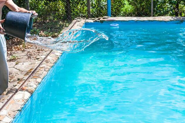  man pours of disinfectant from bucket in pool model released, Symbolfoto, 12.10.2020, Copyright: xvvoennyyx Panthermedia25750407